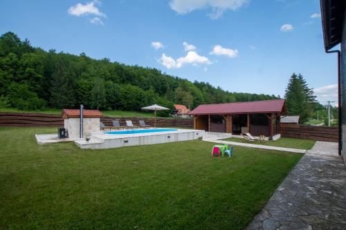 a large yard with a swimming pool and a house at Holiday Home Nina with a heated pool in Brušane