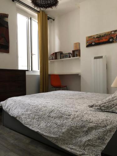 sypialnia z łóżkiem i oknem w obiekcie Appt 2 chambres au centre ville 4è w Marsylii
