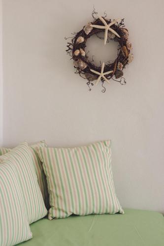 a wreath hanging on a wall above a bed with a pillow at Castria studios in Kionia