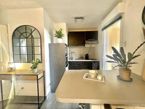- une cuisine avec une table et un comptoir dans une pièce dans l'établissement Grand studio avec coin nuit, proche mer et montagnes, à Roquebrune-sur Argens