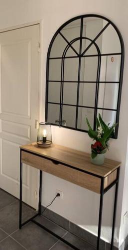 une table avec un miroir et une plante sur elle dans l'établissement Grand studio avec coin nuit, proche mer et montagnes, à Roquebrune-sur Argens