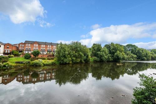 a view of a river with buildings in the background at Zeppelin House - Riverside 18th Century Townhouse in Bewdley