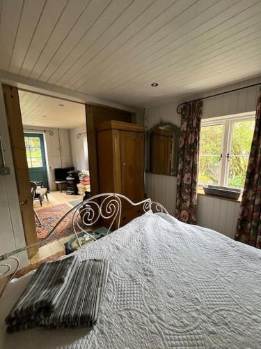 - une chambre avec un lit et un grand miroir dans l'établissement Air Barn at Shepherds Cottage Salisbury, à Coombe Bissett