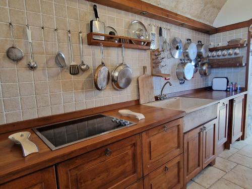 eine Küche mit Spüle und Töpfen und Pfannen an der Wand in der Unterkunft Oliventu - Tra gli ulivi sul mare in Santa Maria di Leuca