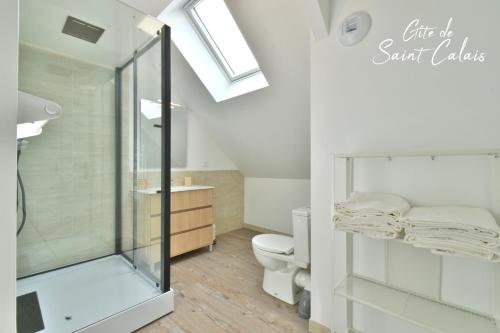 La salle de bains est pourvue d'une douche en verre et de toilettes. dans l'établissement Gîte de saint Calais, à Conches-en-Ouche