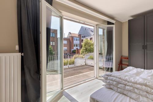 1 dormitorio con 1 cama y puerta corredera de cristal en Premium Holidays - Villa Malibeach Koksijde en Koksijde