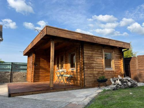 een klein houten huisje met een terras bij Log Cabin in Bideford