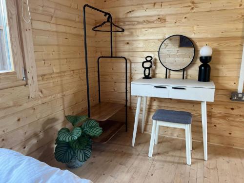 1 dormitorio con escritorio, espejo y silla en Log Cabin en Bideford