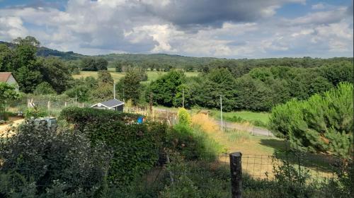 a view of a garden with a fence and trees at Chalet charmant à Saint-Sylvestre avec Terrasse et Jardin in Ambazac
