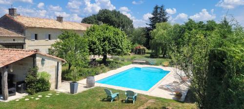 a swimming pool in a yard next to a house at Au Do'Mayne des Bouilles - Spa & Piscine in Lussac