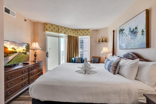 a bedroom with a large bed and a television at Carolinian Corner Gem Views! in Myrtle Beach