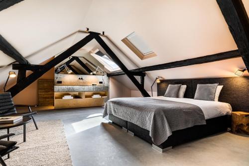 a bedroom with a large bed in a attic at Landgoed Kasteel de Hoogenweerth in Maastricht