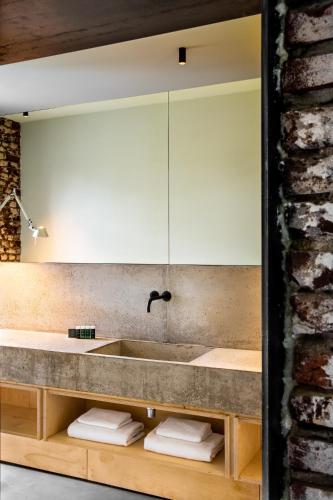 a bathroom with a sink and a brick wall at Landgoed Kasteel de Hoogenweerth in Maastricht