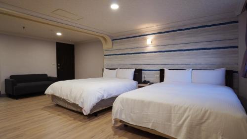a hotel room with two beds and a chair at Su Ao Hotel in Suao