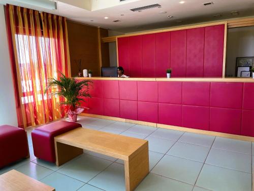 a woman sitting at a counter in a waiting room at Hotel Grecale - Venturina Terme in Venturina Terme