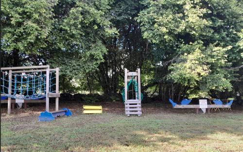 a group of playground equipment in a park at Chalet charmant à Saint-Sylvestre avec Terrasse et Jardin in Ambazac