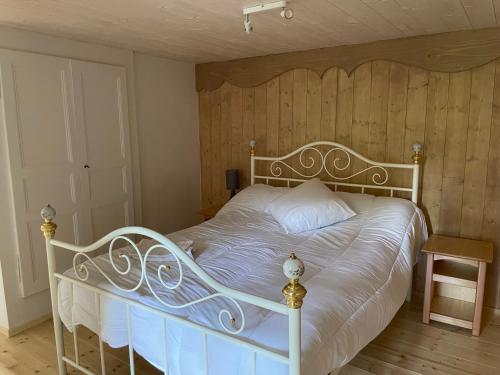 a bedroom with a white bed with a wooden wall at Chez Emile 