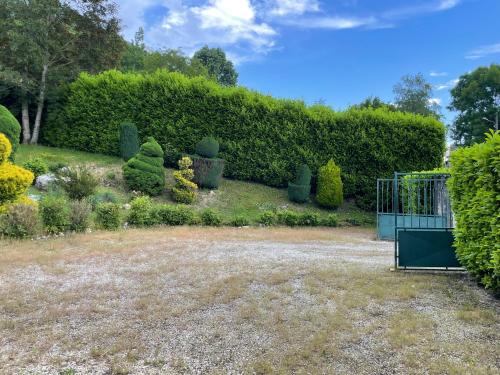 a garden with a gate and bushes at Chez Emile 