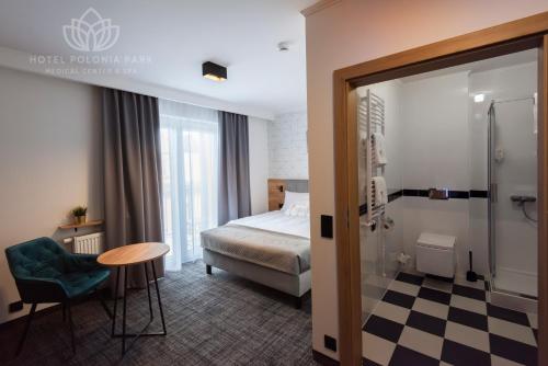 um quarto de hotel com uma cama, uma mesa e uma cadeira em Hotel Polonia PARK Medical Center & Spa em Busko-Zdrój