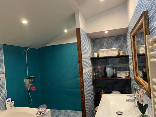 La salle de bains est pourvue d'un mur bleu et d'un lavabo. dans l'établissement Maison à la campagne., à Sollacaro