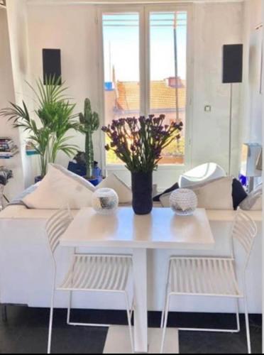 un salon avec une table et des chaises blanches dans l'établissement Cosy penthouse old town sea view little terraces Air conditionned, à Nice