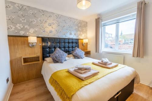 a bedroom with a large bed with two towels on it at 1 Regent Square, Rye - for a perfect break in Rye