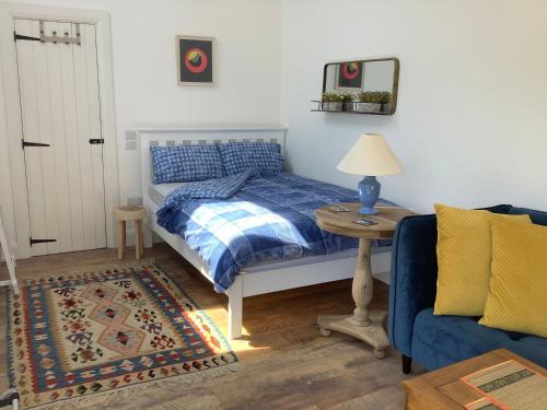 a bedroom with a bed and a table and a couch at Tigh Noor - Escape to Kinvara by the sea! in Galway