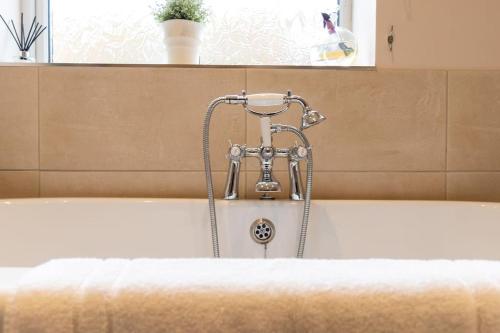 a bath tub with a faucet on top of it at 1 Regent Square, Rye - for a perfect break in Rye