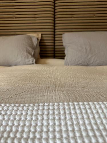 uma cama com lençóis brancos e duas almofadas em Chalet Violettes em Villaroger