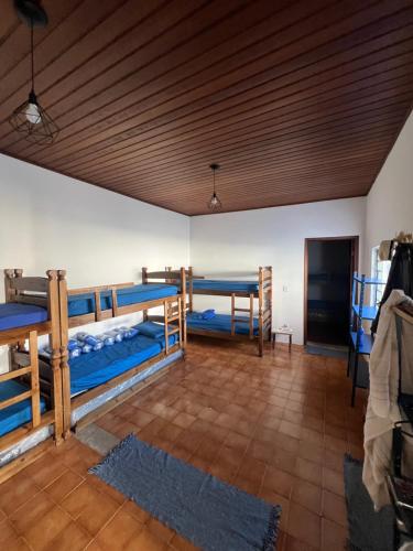 een kamer met 3 stapelbedden en een houten plafond bij Açaipoint Hostel in Águas da Prata
