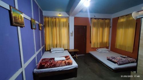 2 camas en una habitación con cortinas amarillas en Khowti Stay, en Dirang Dzong