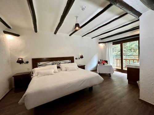 una camera da letto con un grande letto bianco in una stanza di Hatun Inti Boutique a Machu Picchu
