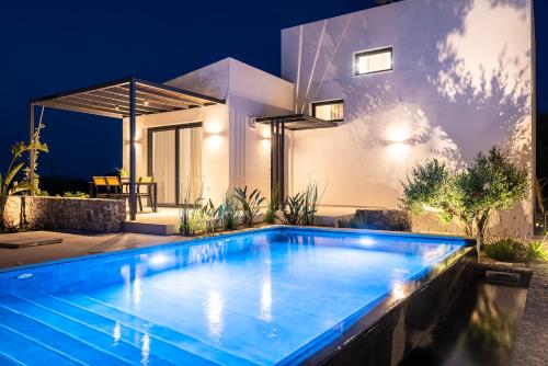 - une piscine en face d'une maison la nuit dans l'établissement Campo Premium Stay Private Pool Villas, à Kos
