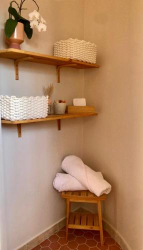 une pièce avec des étagères au mur avec un tabouret dans l'établissement L’Hacienda Maison d’hôtes, à Bagnols-en-Forêt