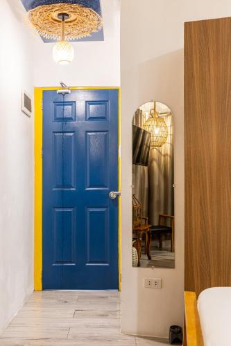 a blue door in a room with a mirror at Rain Airport Bed and Breakfast in Manila