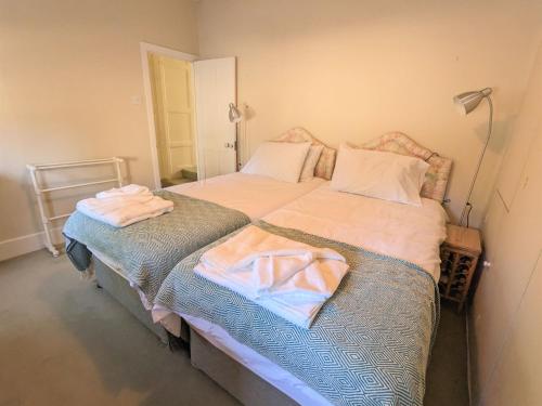 een slaapkamer met 2 bedden en handdoeken bij Rose Cottage in Bembridge