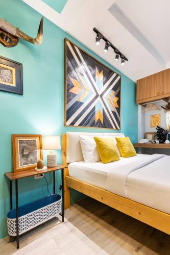 a bedroom with a bed and a blue wall at Rain Airport Bed and Breakfast in Manila