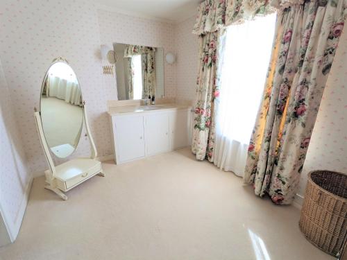 een badkamer met een wastafel en een spiegel bij Rose Cottage in Bembridge