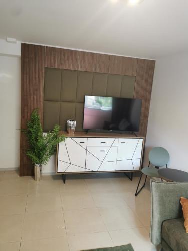 een woonkamer met een flatscreen-tv aan de muur bij Mrągowski Apartament 1 in Mrągowo
