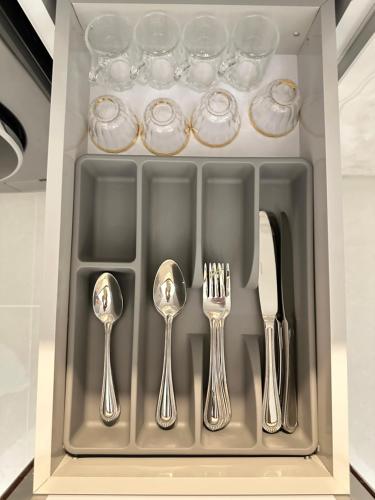 a drawer with silver utensils and wine glasses at Mehad Stay for Self Check-In Apartment in Jeddah