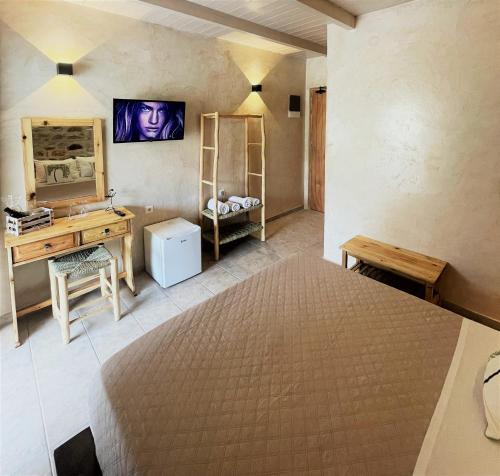 a bedroom with a bed and a desk and a mirror at Marmari Paradise Resort Hotel in Marmari