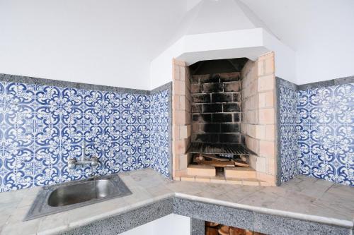 a kitchen with a fireplace with blue and white tiles at Kayak Azores in Ponta Delgada