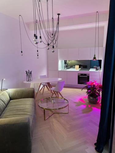 un soggiorno con divano e tavolo con luci rosa di City Apartment Downtown Vienna a Vienna