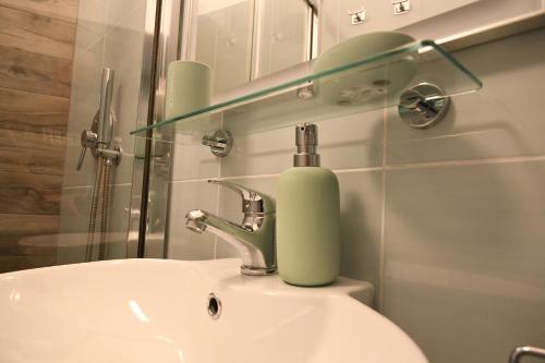 a bathroom with a sink with a soap dispenser on it at Jolie Maison in Brindisi