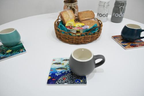a table with a basket of bread and a cup at Jolie Maison in Brindisi