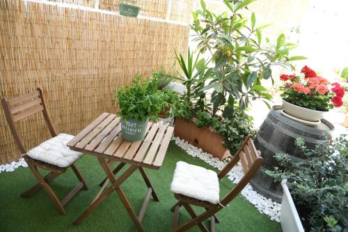 a patio with a table and two chairs and plants at Jolie Maison in Brindisi