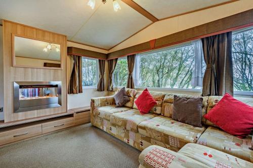 ein Wohnzimmer mit einem Sofa und einem TV in der Unterkunft Sandcastle Mobility Lodge in Christchurch