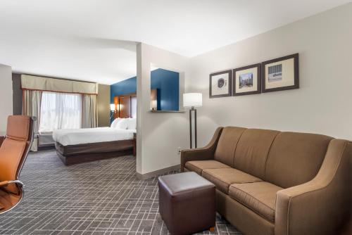 a hotel room with a couch and a bed at Comfort Suites Atlanta Airport in Forest Park