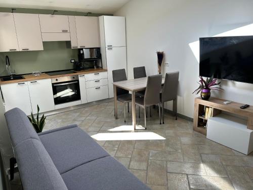 a living room with a couch and a table with chairs at Appartamento vicino spiaggia in Portoscuso