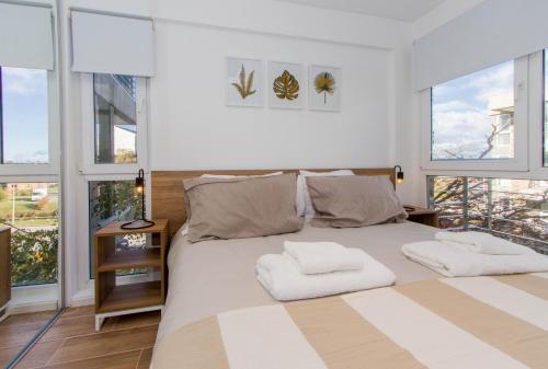 een slaapkamer met een groot bed met 2 kussens erop bij Gray Fox Apartments Pipo in Ushuaia